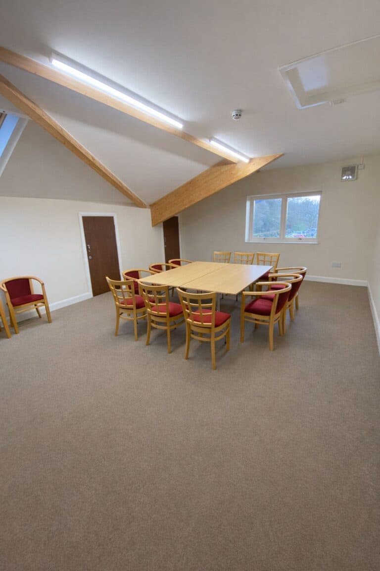 Interior of a meeting room with a large table and chairs at Cookley Village Hall.