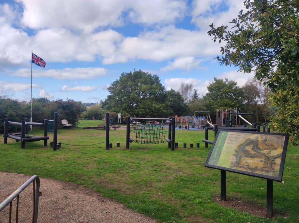 Playground with climbing frames, swings, and a colourful net for children to enjoy.